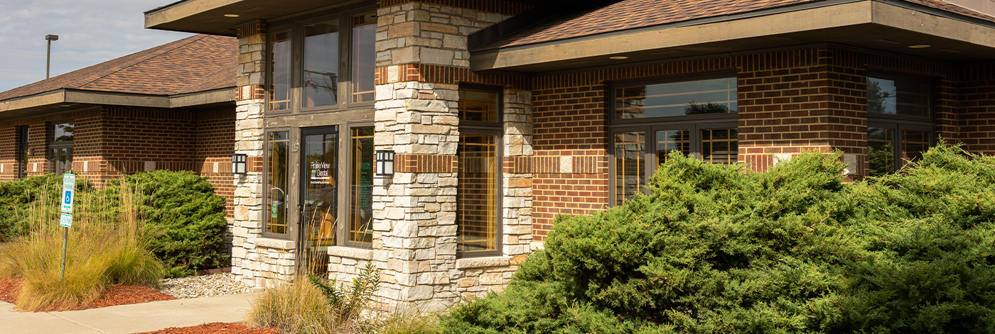 Green shrubs on either side of the entrance to Grand Dental - Prairie View